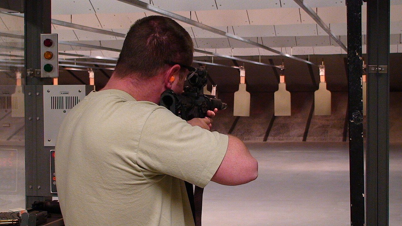 Shooter at an indoor firing range facing downrange targets