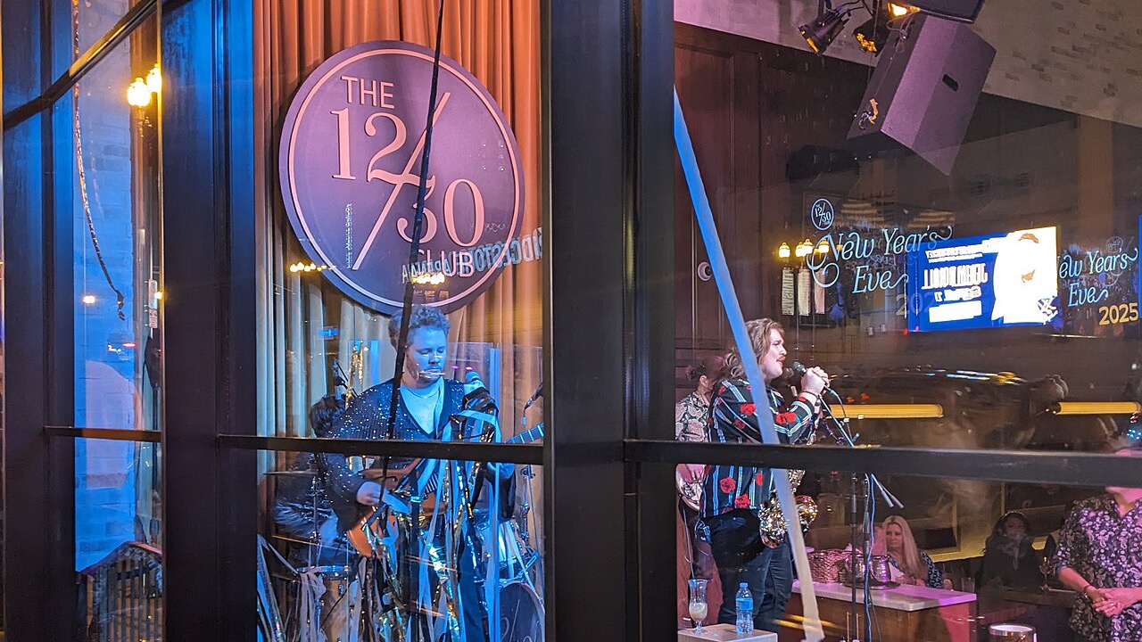 The Twelve Thirty Club on Broadway at night — live band playing behind the 12|30 sign